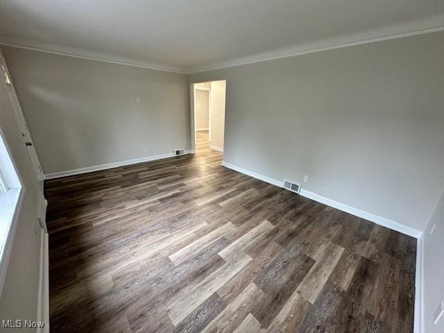 30119 Harrison St, Willowick, OH 44095 - spare room featuring crown molding, baseboards, dark wood finished floors, and visible vents