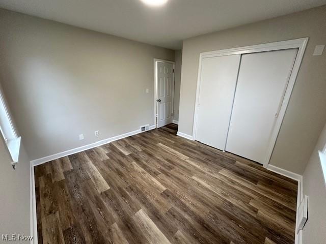 30119 Harrison St, Willowick, OH 44095 - unfurnished bedroom featuring baseboards, a closet, dark wood-style flooring, and visible vents