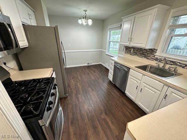 30119 Harrison St, Willowick, OH 44095 - kitchen with white cabinets, appliances with stainless steel finishes, a sink, and dark wood-type flooring