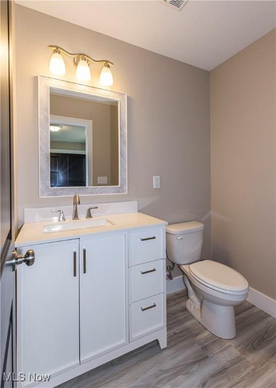 bathroom featuring toilet, baseboards, and wood finished floors