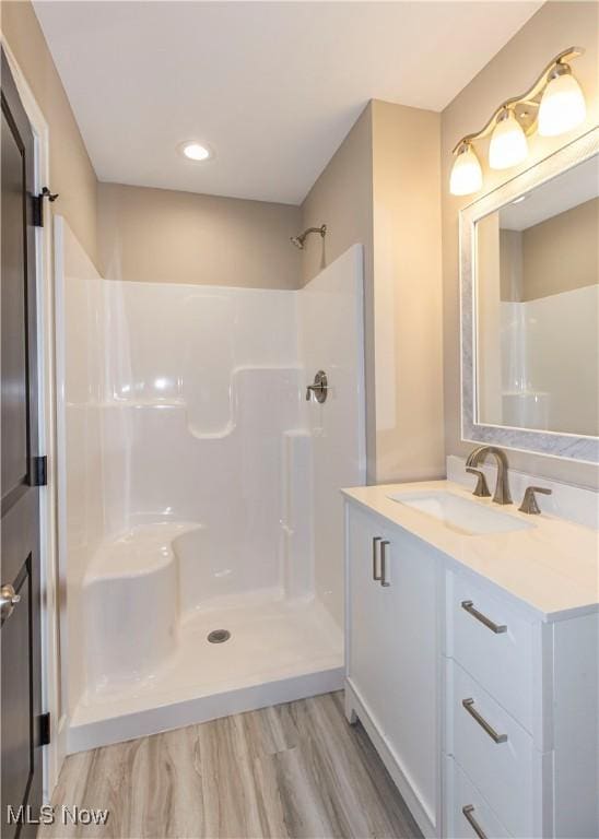 full bath with vanity, recessed lighting, walk in shower, and wood finished floors