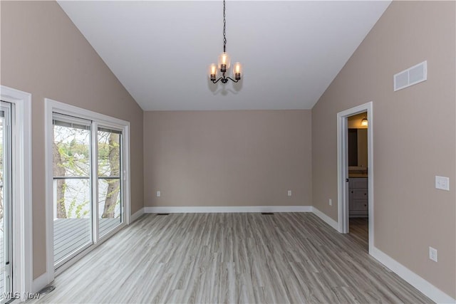 spare room with visible vents, light wood-type flooring, baseboards, and an inviting chandelier