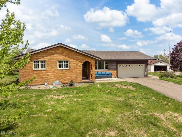 ranch-style house with driveway, an outdoor living space, a garage, brick siding, and a front lawn