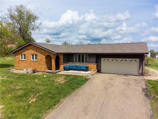 ranch-style house with brick siding, a garage, a front yard, and aphalt driveway