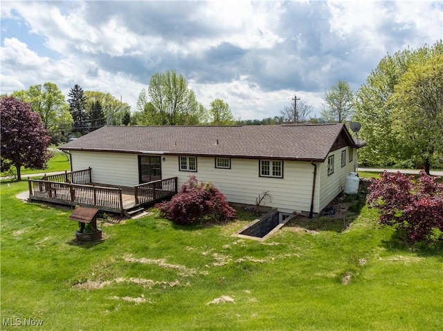 rear view of property featuring a lawn and a wooden deck