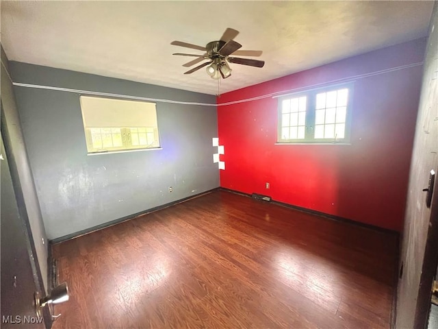 spare room with baseboards, ceiling fan, and wood finished floors
