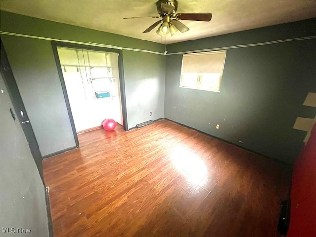 spare room featuring baseboards, ceiling fan, and wood finished floors