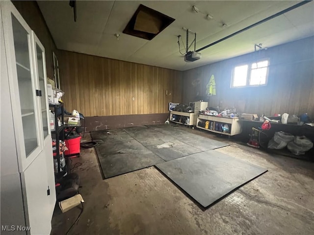 garage with wooden walls and a garage door opener