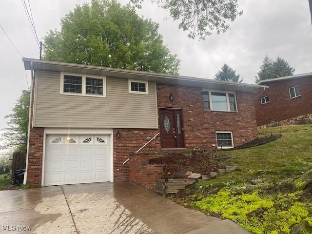 1113 21st St, Vienna, WV 26105 - raised ranch featuring brick siding, an attached garage, and concrete driveway