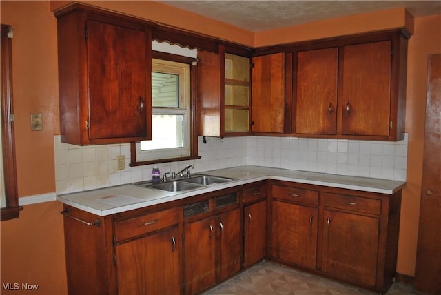 kitchen with a sink, backsplash, and light countertops