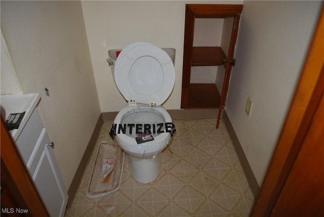 bathroom featuring baseboards and toilet