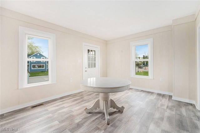 unfurnished dining area with visible vents, baseboards, and wood finished floors
