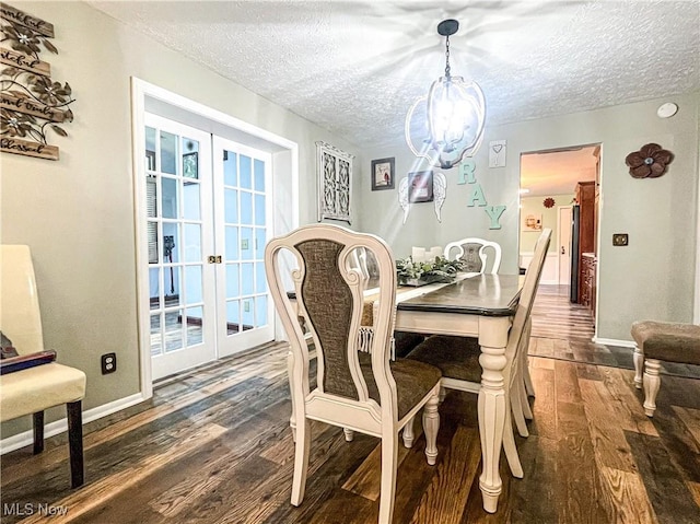 dining area featuring french doors, a textured ceiling, baseboards, and dark wood finished floors
