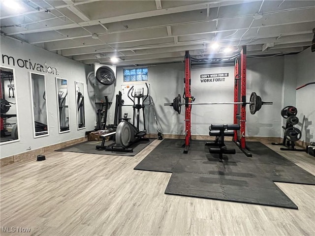 exercise area with baseboards and wood finished floors