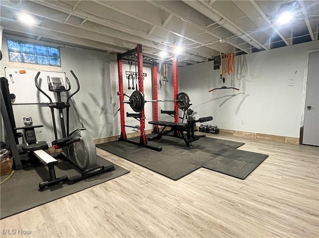 exercise area featuring baseboards and wood finished floors