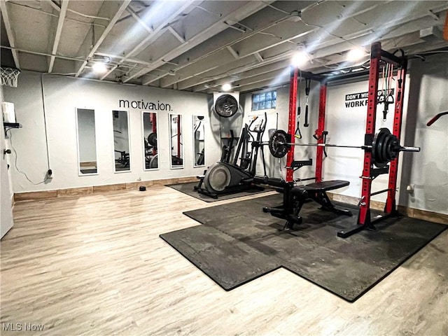 workout area featuring baseboards and wood finished floors
