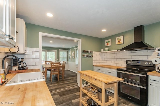 7599 Fairview Ave, Mentor, OH 44060 - kitchen with butcher block countertops, wall chimney exhaust hood, white cabinets, range with two ovens, and a sink