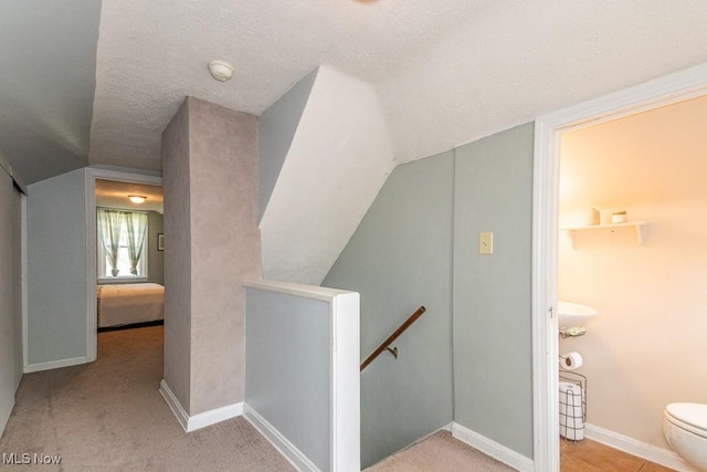 7599 Fairview Ave, Mentor, OH 44060 - interior space featuring a textured ceiling, carpet, baseboards, an upstairs landing, and vaulted ceiling