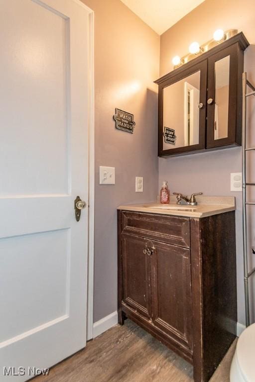 7599 Fairview Ave, Mentor, OH 44060 - bathroom with toilet, baseboards, wood finished floors, and vanity