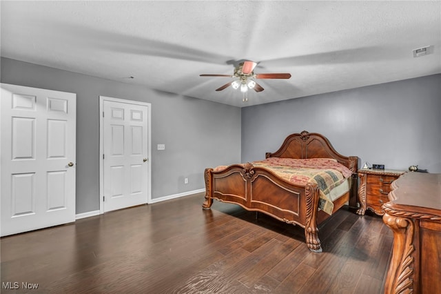 bedroom featuring visible vents, wood finished floors, baseboards, a textured ceiling, and a ceiling fan