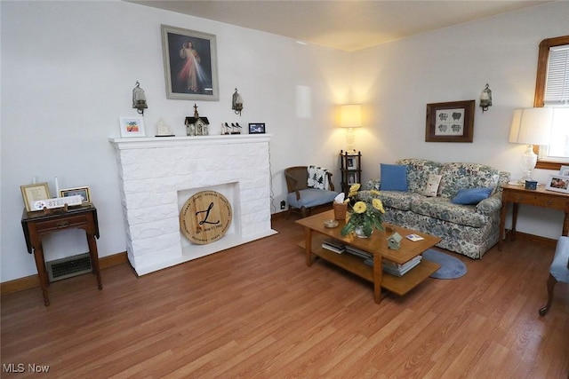 living area featuring light wood-type flooring and a fireplace with flush hearth