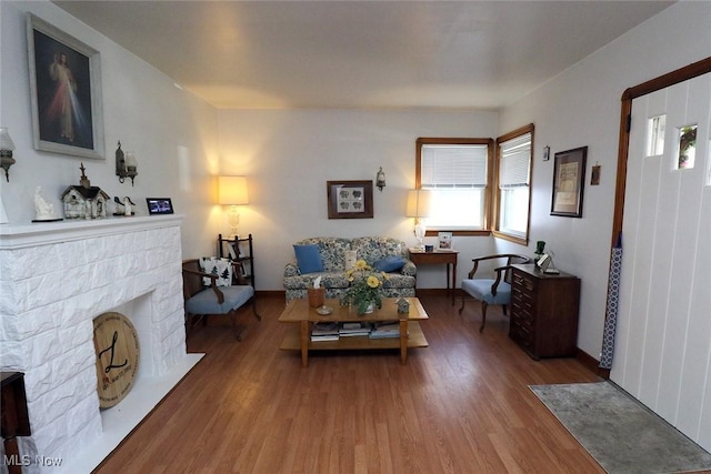living area with a fireplace with flush hearth and wood finished floors