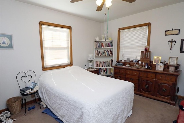 bedroom featuring multiple windows, a ceiling fan, and light colored carpet