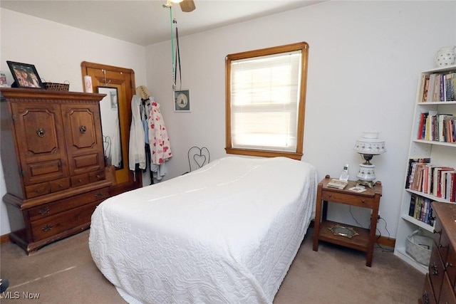 bedroom featuring light carpet and a ceiling fan