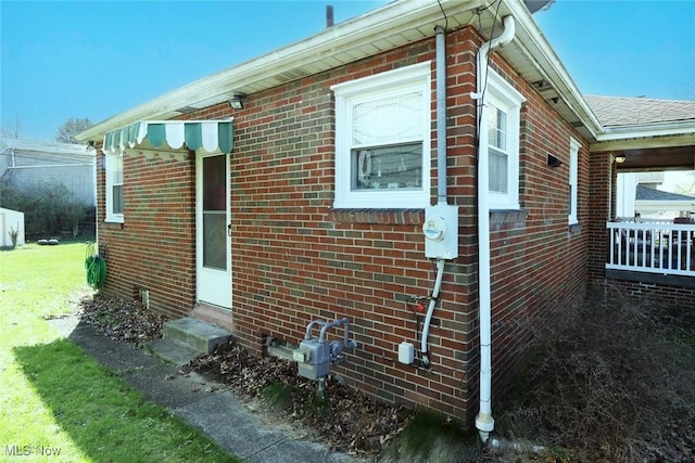 view of side of home featuring brick siding and entry steps