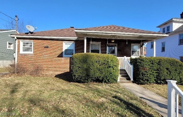 view of front facade with covered porch, brick siding, and a front lawn