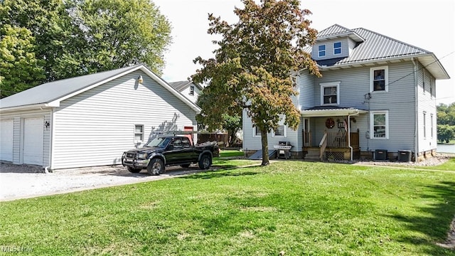back of house featuring a garage, central air condition unit, a yard, and metal roof