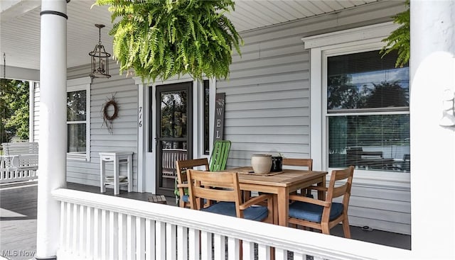 wooden deck featuring a porch and outdoor dining space