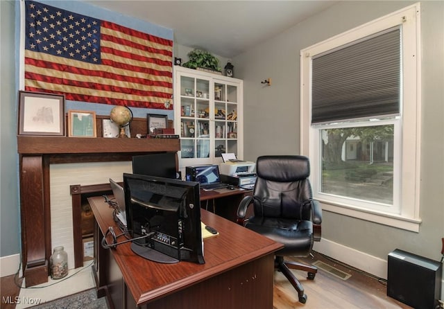 office space with visible vents, baseboards, and wood finished floors