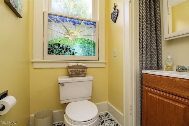 bathroom with vanity, baseboards, and toilet