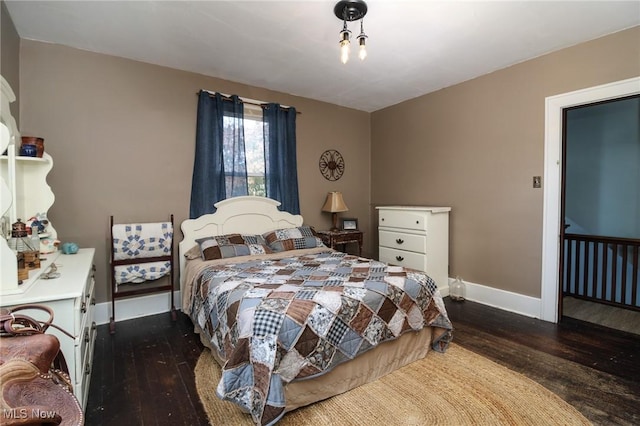 bedroom with baseboards and hardwood / wood-style flooring