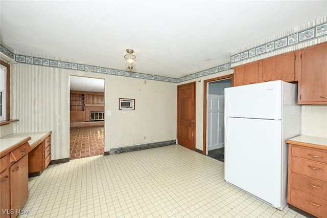 kitchen featuring freestanding refrigerator, brown cabinetry, a baseboard radiator, and light countertops