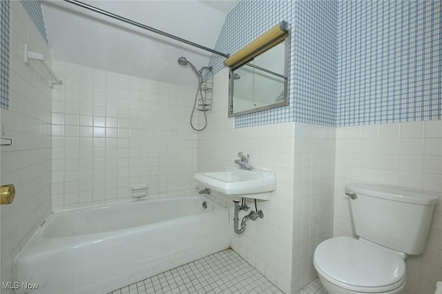 bathroom featuring toilet, wallpapered walls, tile patterned floors, tile walls, and shower / bathing tub combination