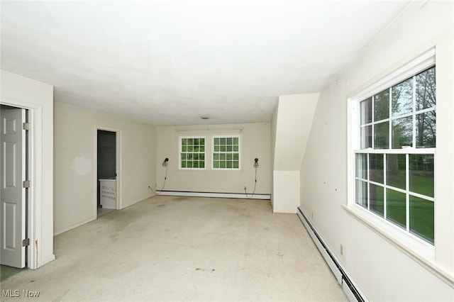 spare room with a baseboard radiator, baseboards, and plenty of natural light