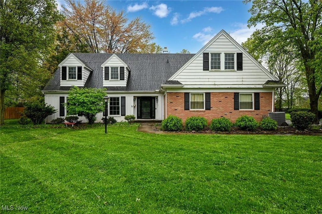 5233 S Park Dr, Lorain, OH 44053 - cape cod-style house with cooling unit, fence, a front yard, brick siding, and roof with shingles