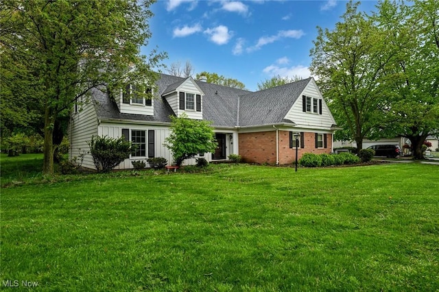 cape cod home with a front lawn, board and batten siding, and brick siding