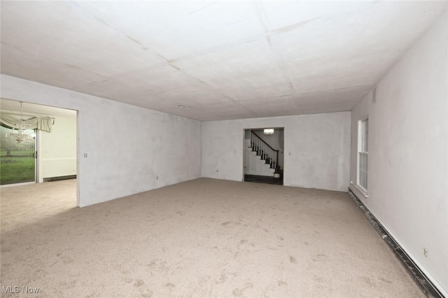 spare room featuring stairs and carpet