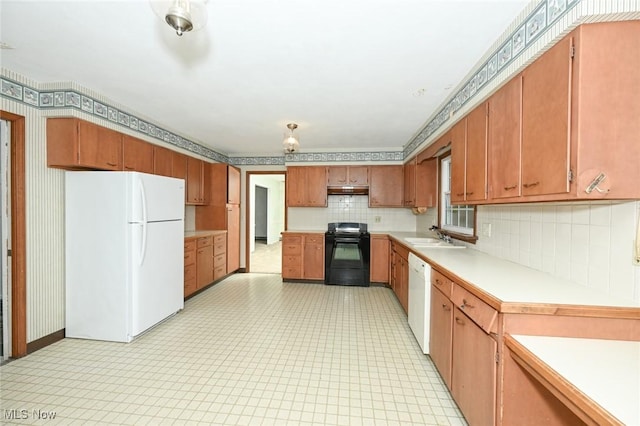kitchen featuring a sink, white appliances, tasteful backsplash, under cabinet range hood, and light countertops