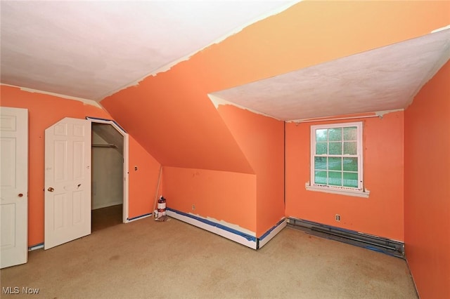 bonus room with a baseboard radiator, carpet, and vaulted ceiling