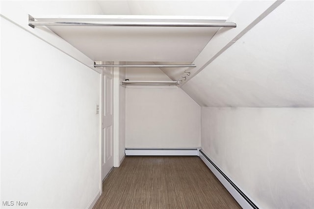walk in closet with a baseboard heating unit and vaulted ceiling