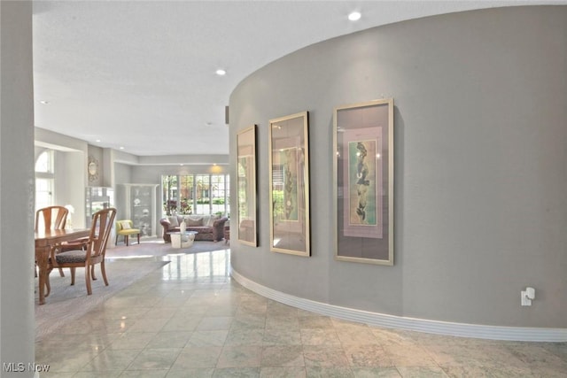 hallway with baseboards and recessed lighting