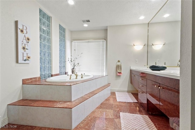 full bathroom featuring double vanity, a garden tub, visible vents, baseboards, and recessed lighting