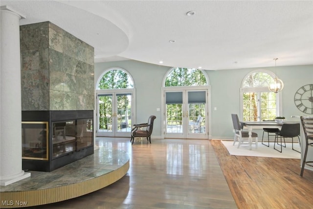 living area featuring french doors, recessed lighting, baseboards, wood finished floors, and a tile fireplace