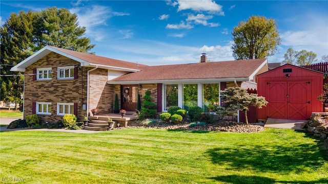 view of front of home featuring a storage unit, a chimney, an outdoor structure, a front yard, and brick siding