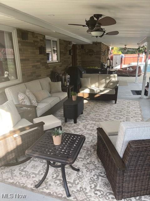 view of patio with ceiling fan, fence, and an outdoor living space