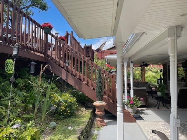 view of patio / terrace featuring an outdoor living space, stairs, and ceiling fan